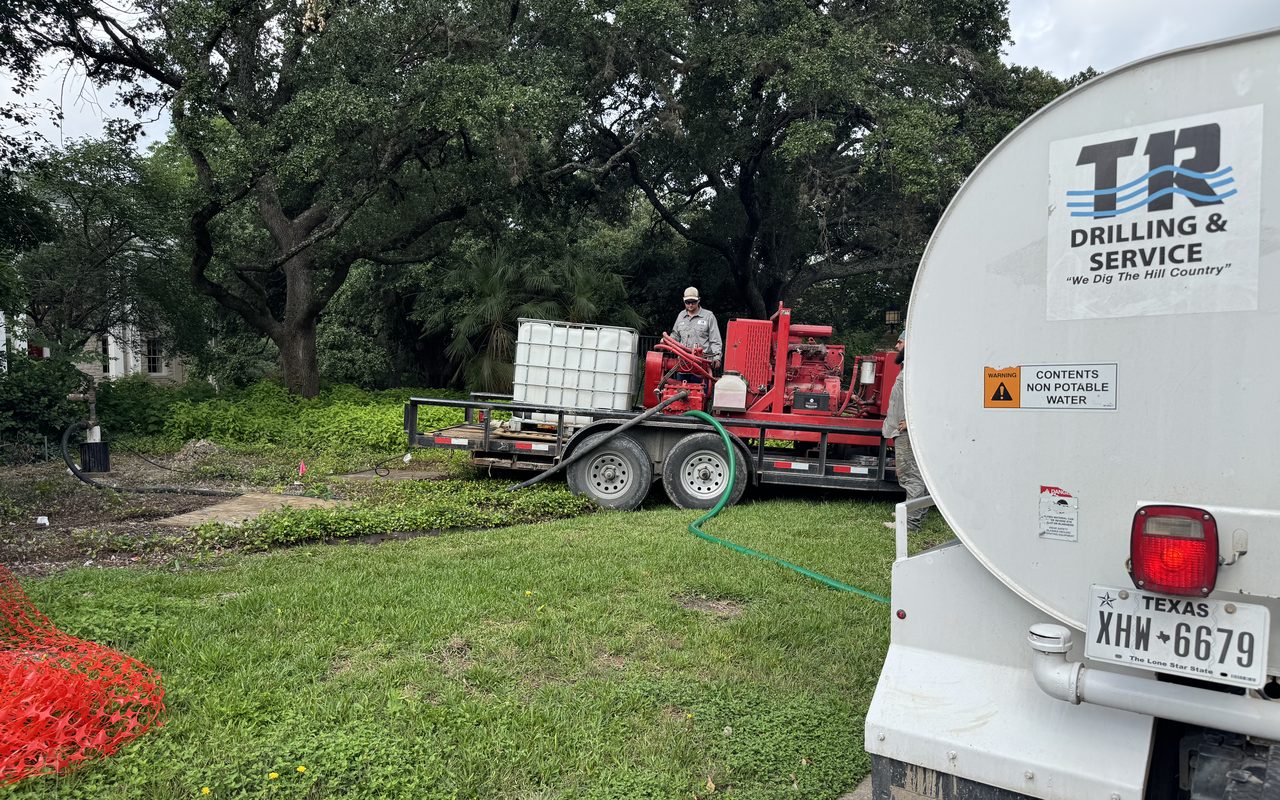 A TR Drilling acidizing rig and chemical totes set up at a Hill Country well, with the TR service truck alongside