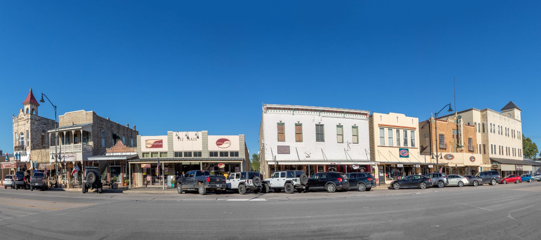 Historic Main Street buildings in Fredericksburg, Texas, under a clear blue sky