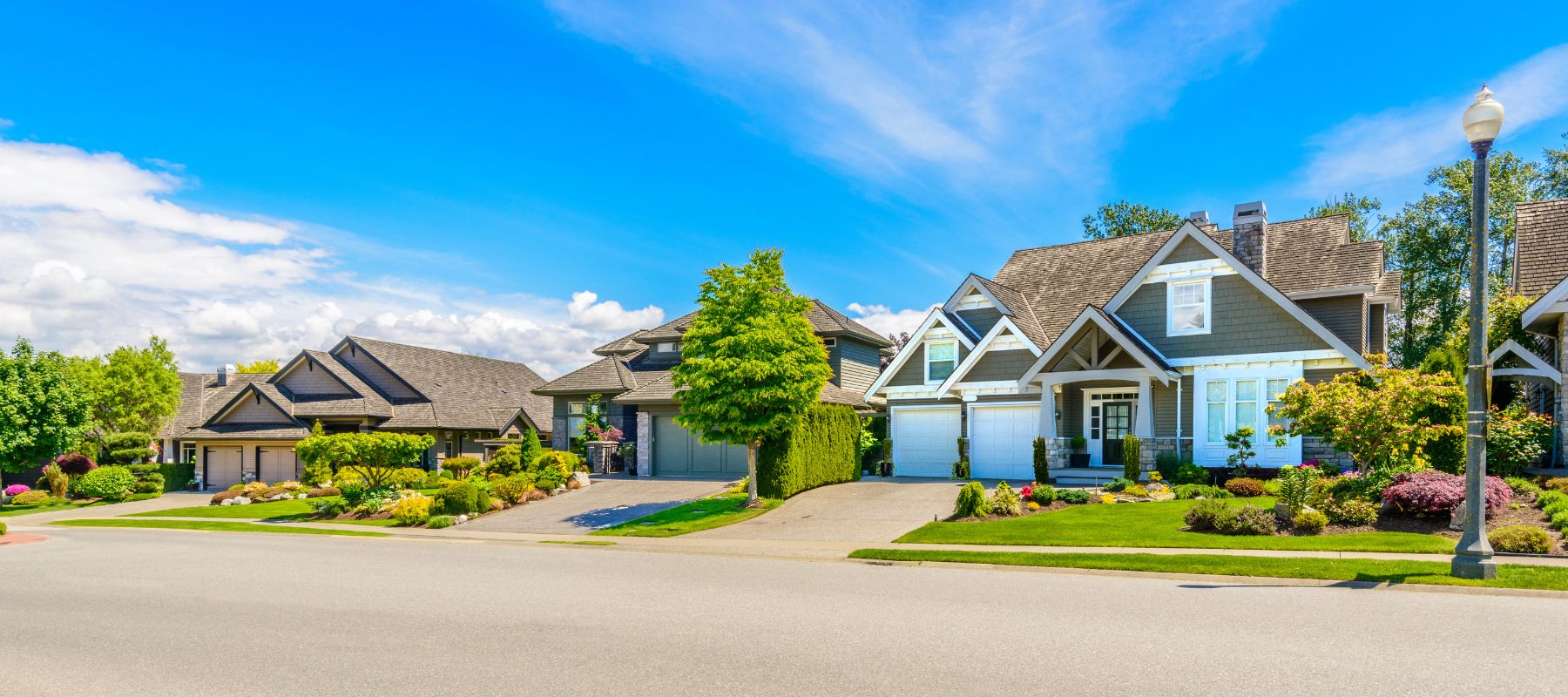 Well-kept suburban homes with landscaped yards along a quiet residential street