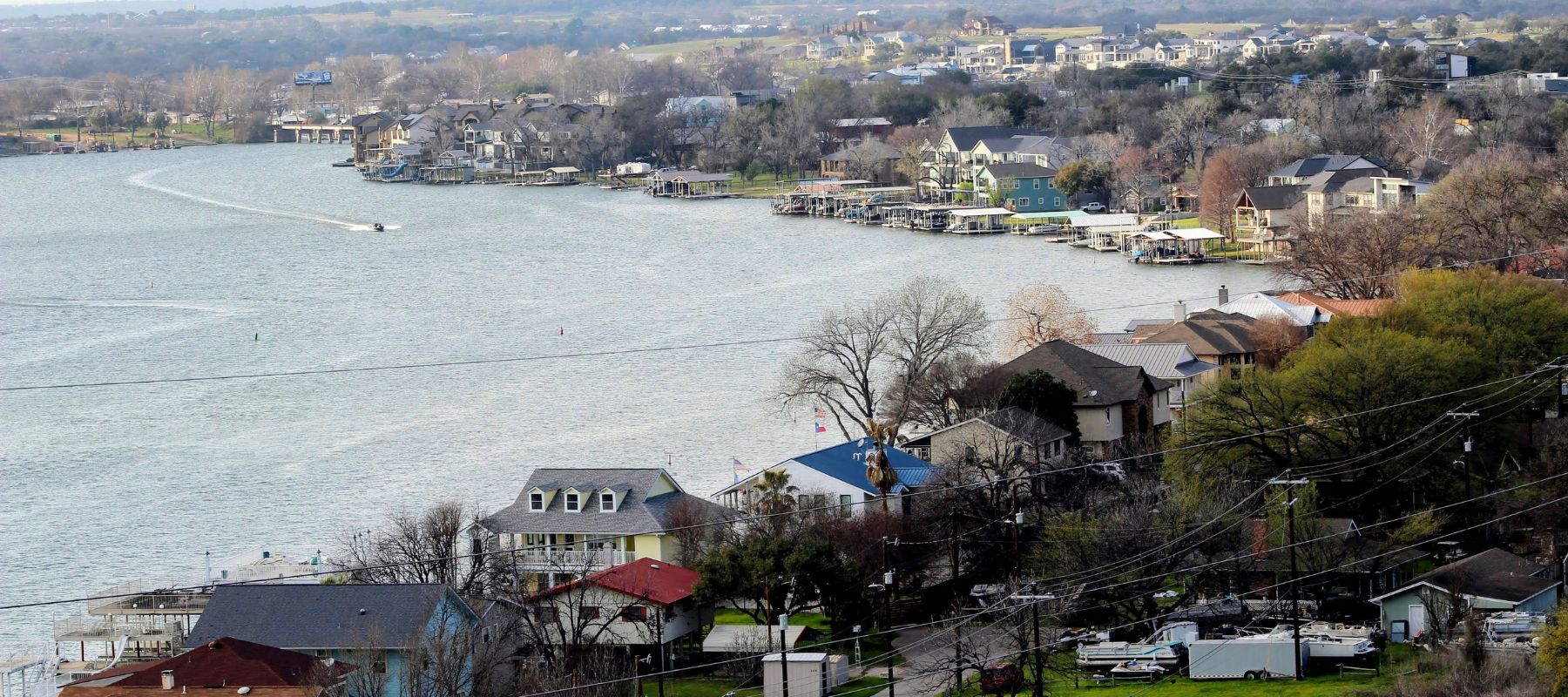 Aerial view of lakeside homes and docks along a wide river